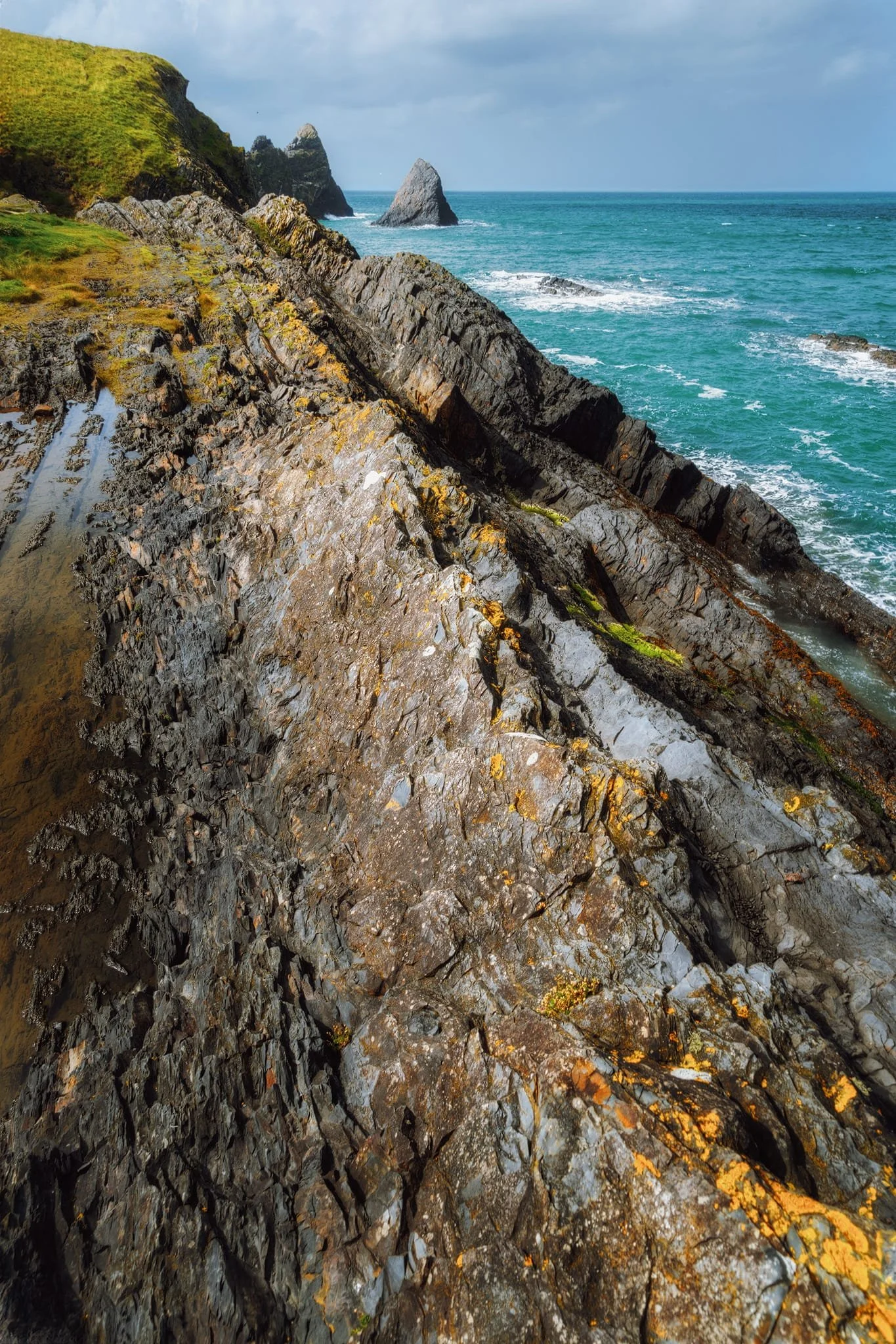 A particularly sharp fold served as a dominant leading line towards the two shark fin sea stacks of Careg Wylan .