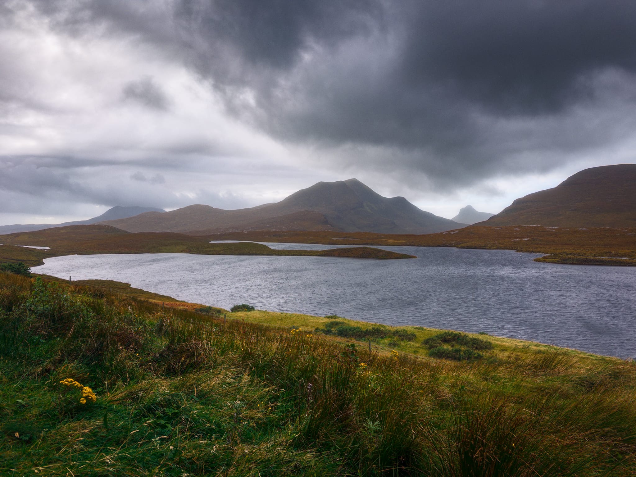 A wider composition from the same vantage point. I really tried to give this photo the impression of everything being battered by the storm’s winds; grass swaying wildly, ripples racing across the lochan, and mobile clouds crashing into each other.