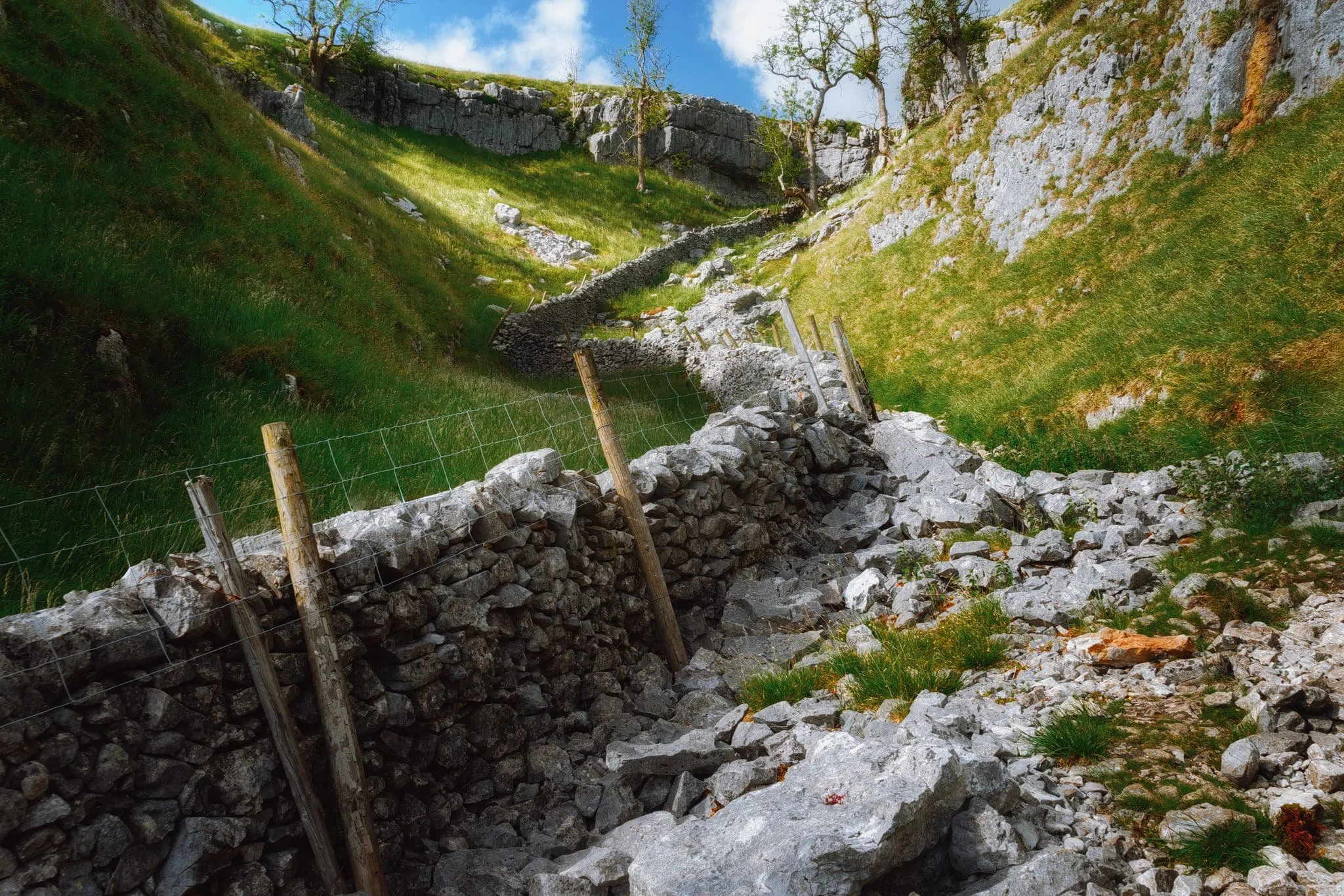 Halfway up the dry gorge of Conistone Dib. An old drystone wall leads the way up, as does the ankle-breaking loose limestone scree.
