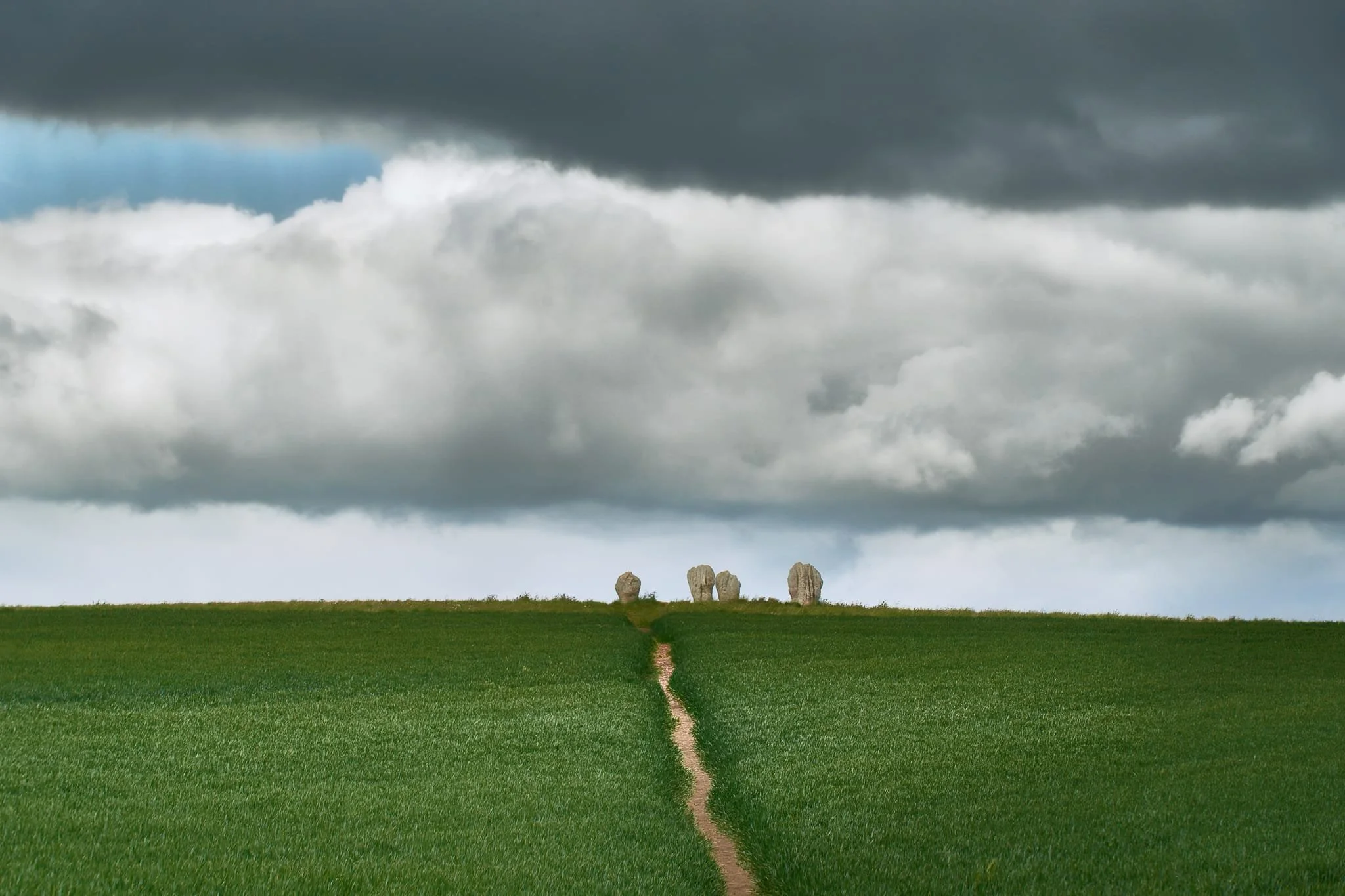Approaching the stone circle. The land is privately owned, but the landowners have maintained a right of way to the stones for the public to enjoy. Above, storm clouds gather.