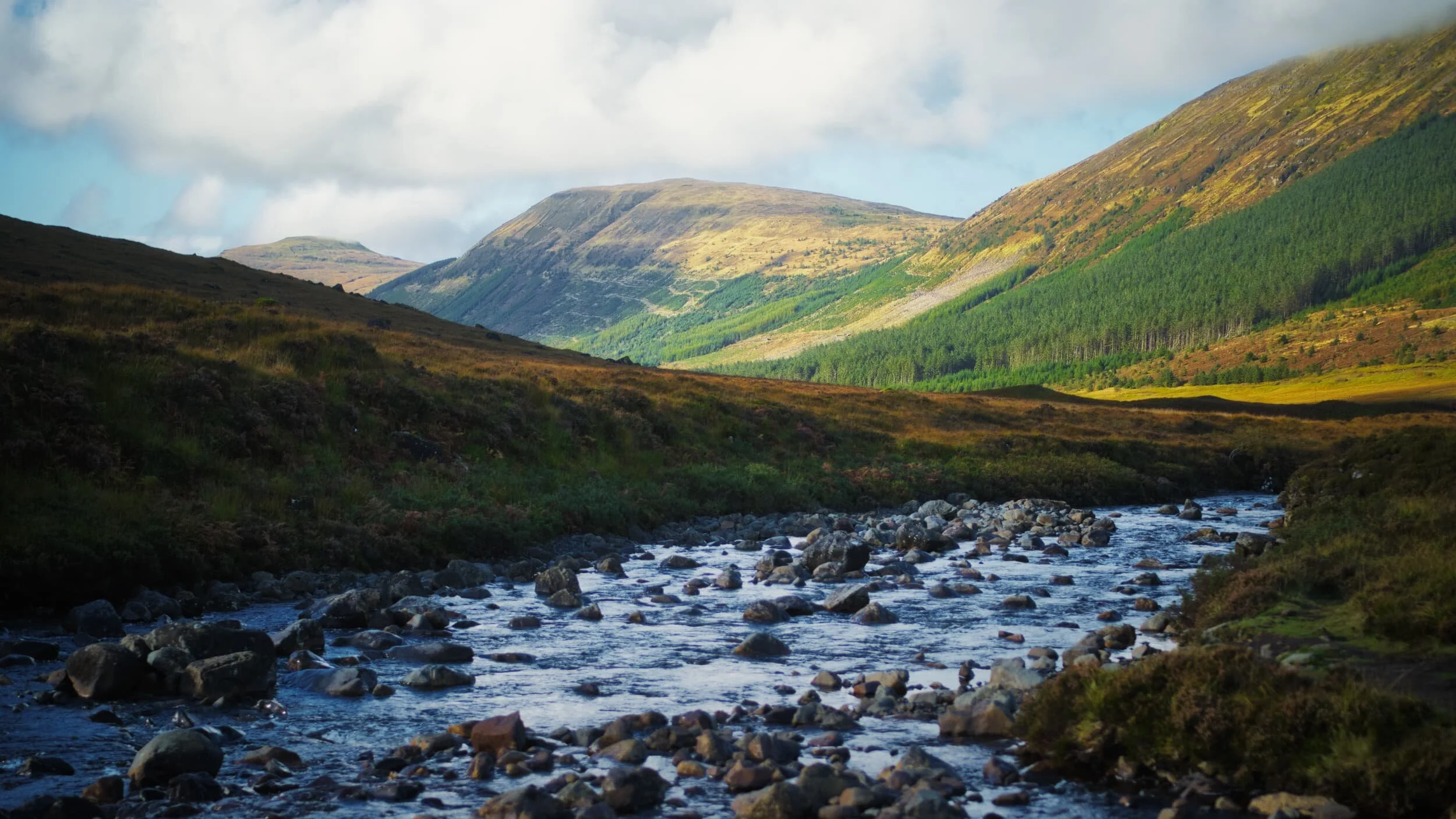 The hills that form the western side of the Glen Brittle valley, catching the post-sunrise light. Right to left: Beinn a’ Bhràghad (459 m/1,505 ft), Beinn Staic (412 m/1,351 ft), and An Cruachan (435 m/1,427 ft).