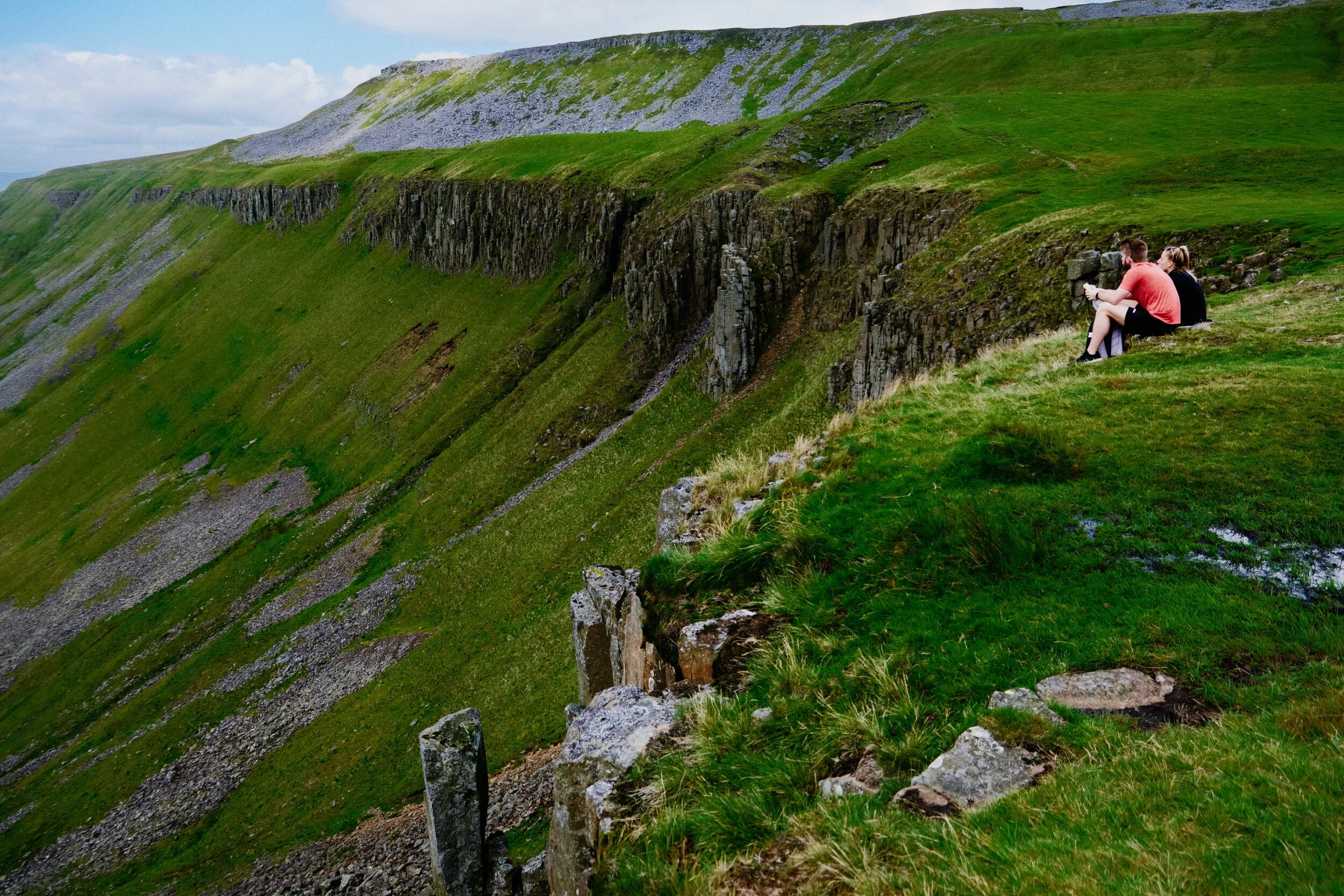 A young couple rest and enjoy the views near the head of High Cup Nick.