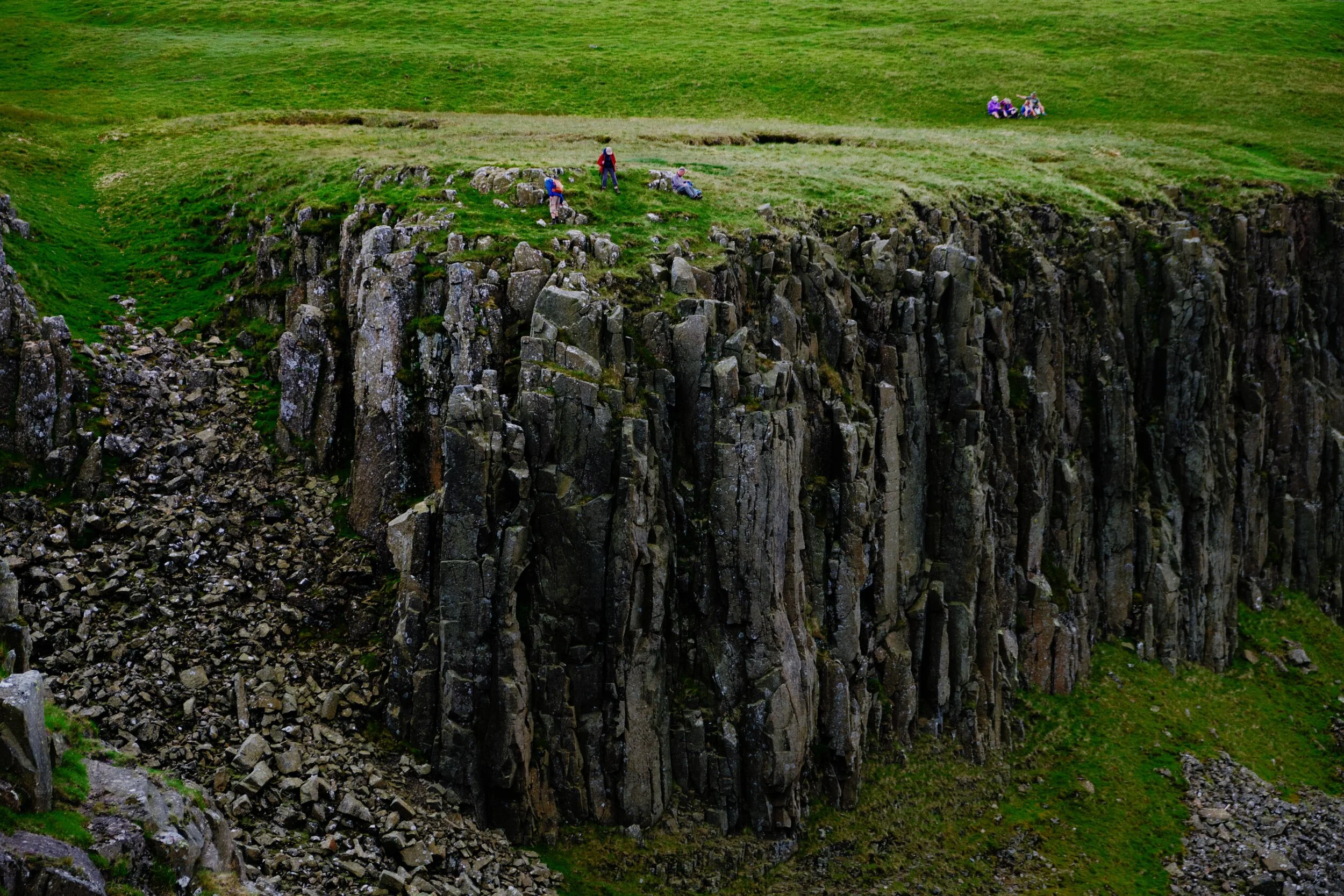 Tiny people near the edge of the cliffs at High Cupgill Head.