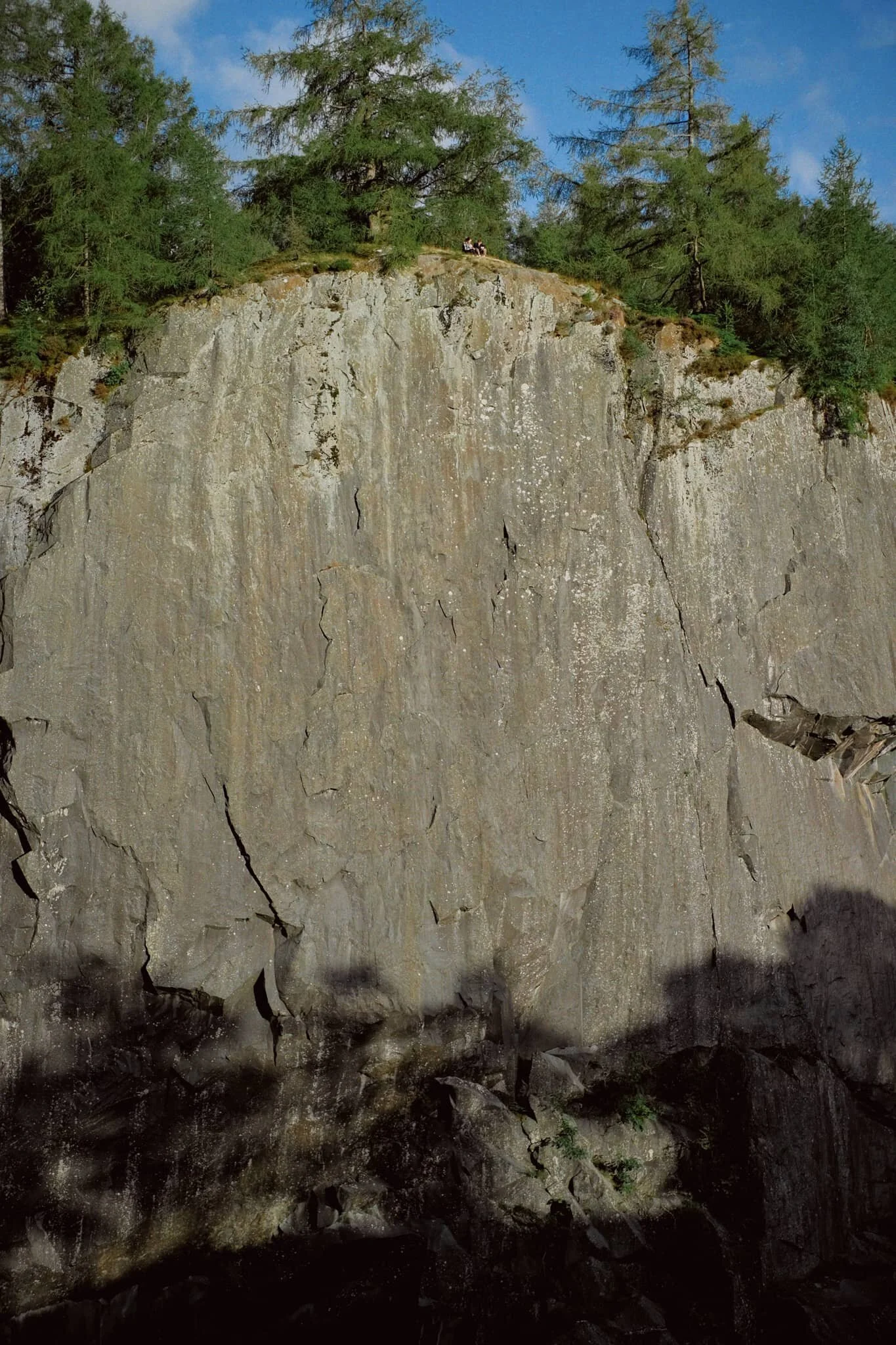 The first sight you see of Hodge Close Quarry. Quite the drop, eh? 150 ft down to the dark pool below. A young couple perched on top of the crag gives you a sense of scale.