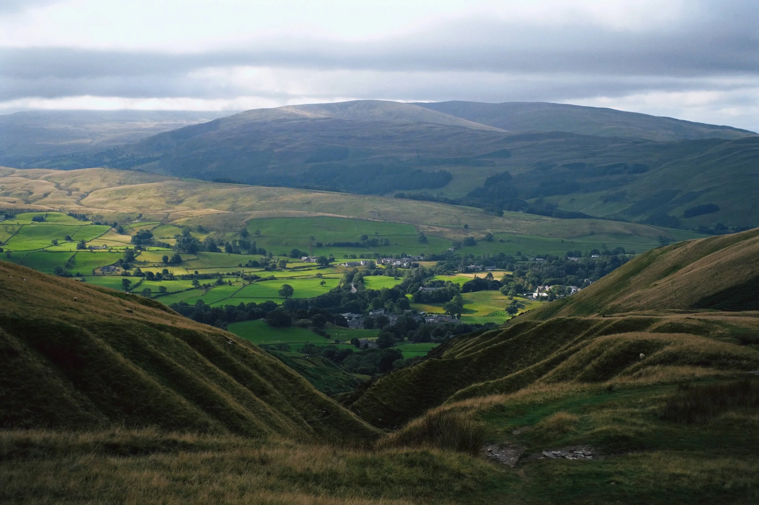 The steep folds of Settlebeck Gill, leading down to Sedbergh and the Barbondale fells beyond.