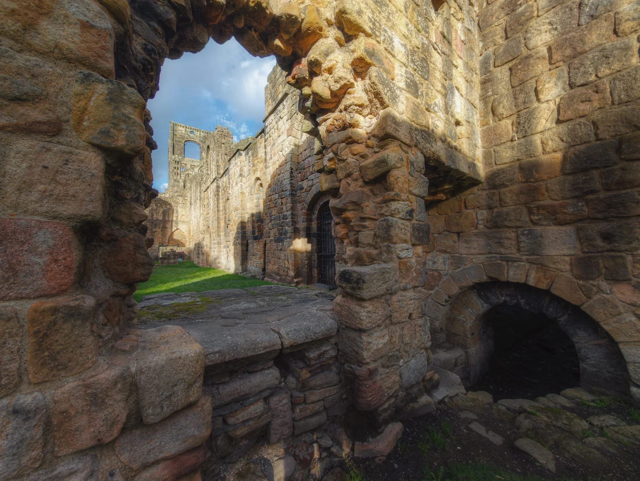 A framing composition from within the old shadowed kitchen looking towards the illuminated tower.