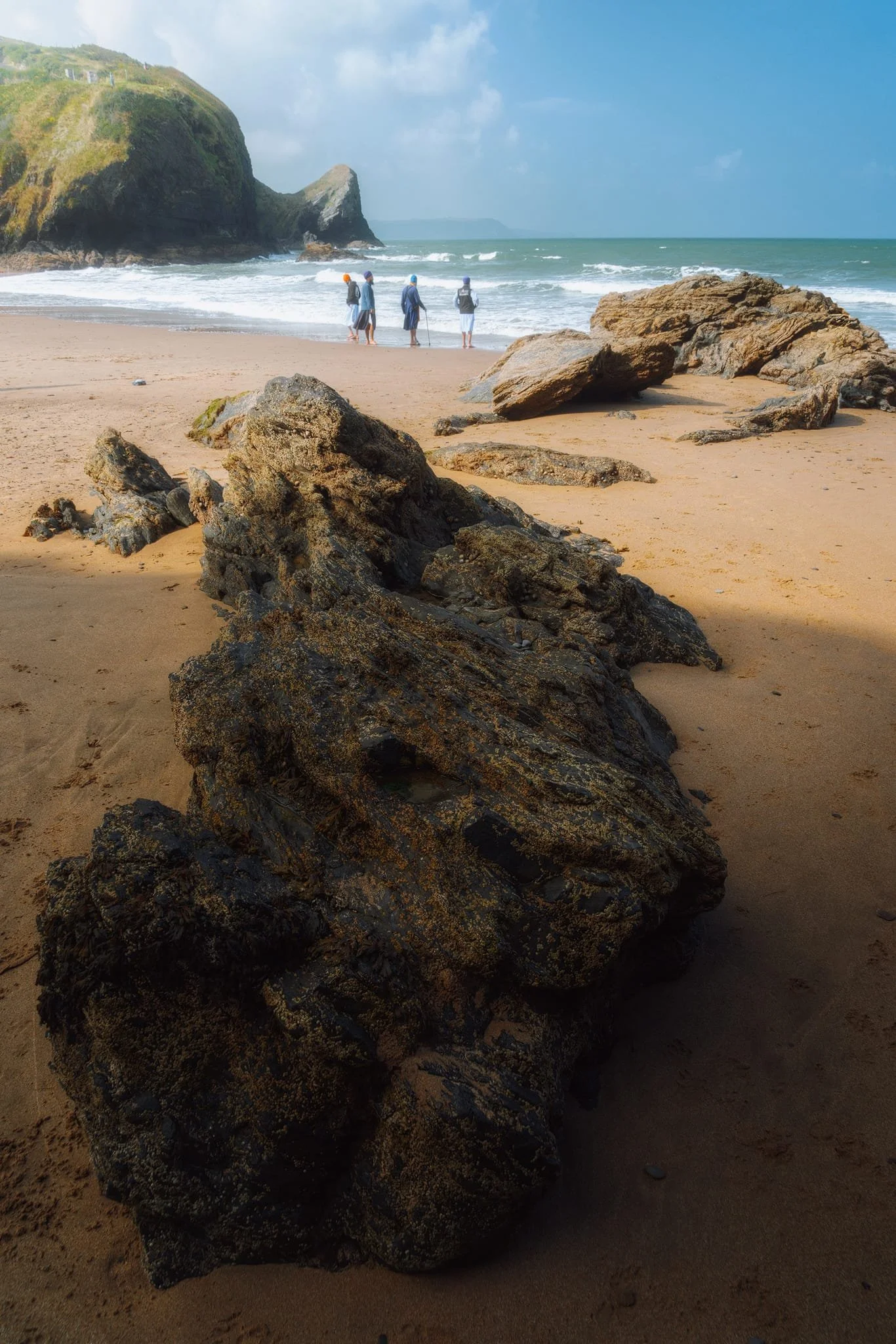 I line up a series of beach boulders and outcrops in this composition towards Pen-rhip again. Also included: A group of Sikh gentlemen enjoying the sea and the scenes.