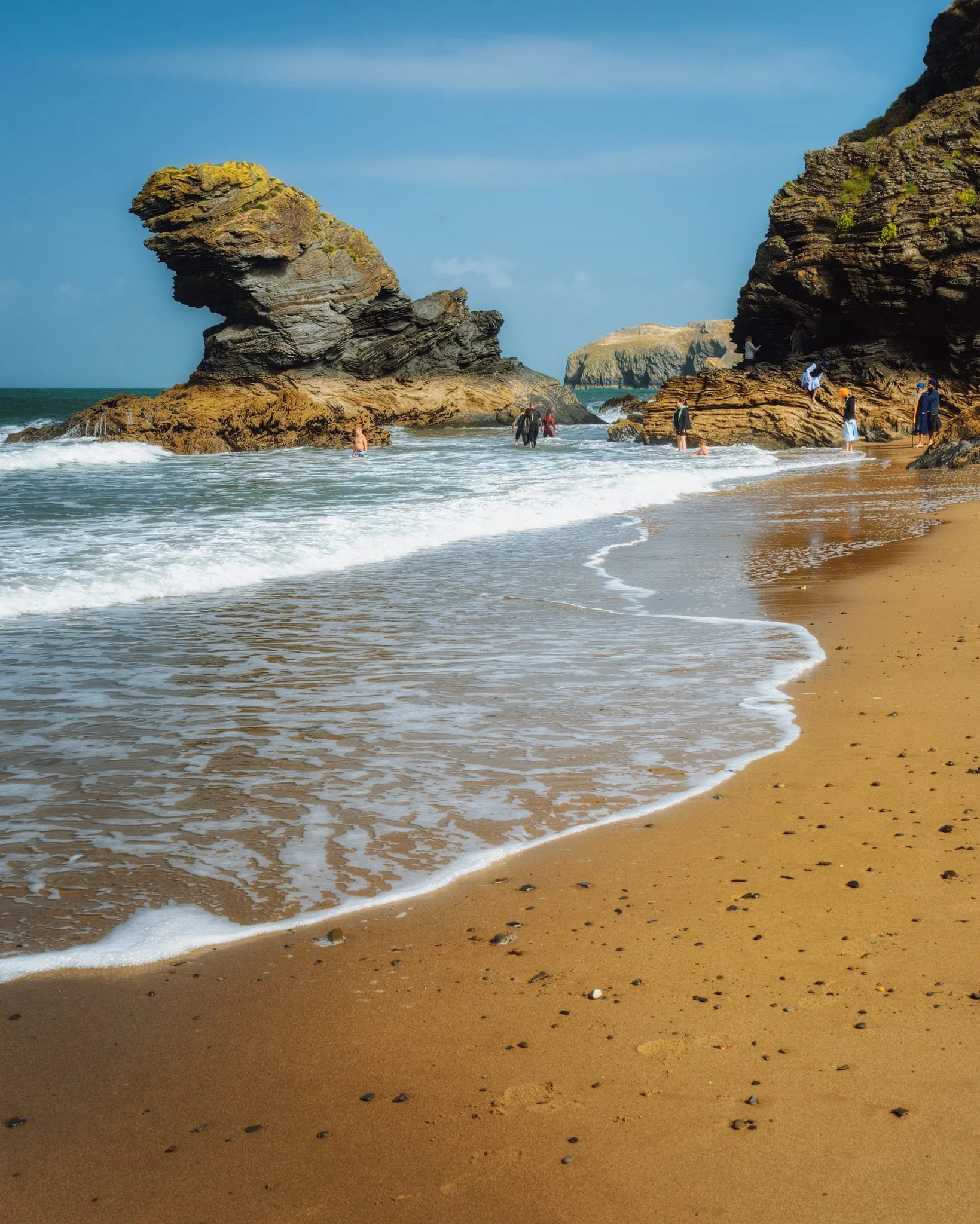 A simpler image of Carreg Bica , with people playing around its base for scale. I waited for the rising tidal waves and shot multiple frames to get the waves in just the right shape and angle.