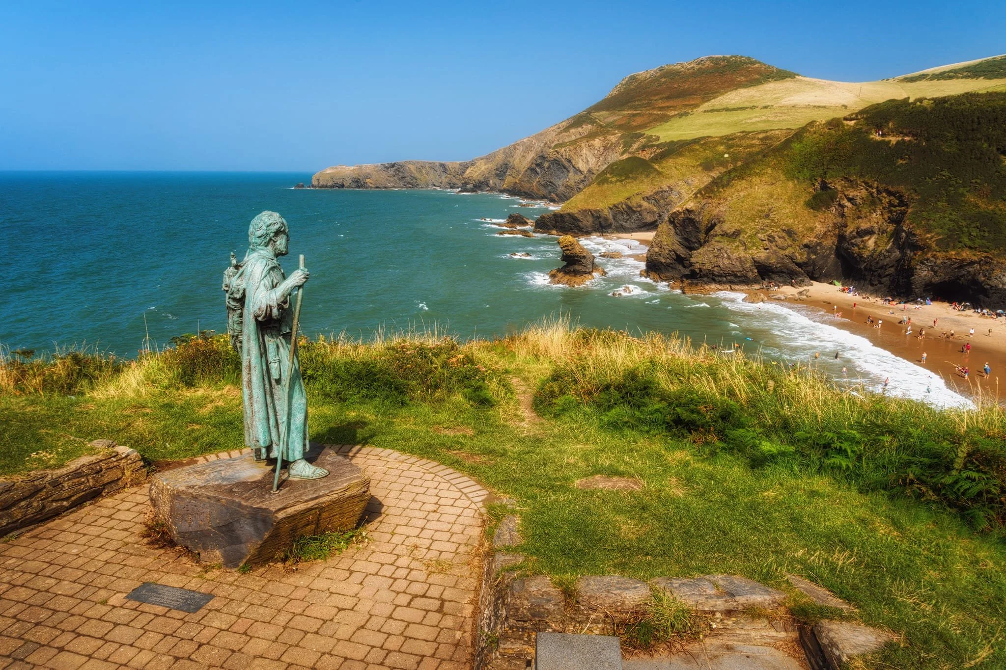 Returning back to Llangrannog, the southern cliffs are home to this statue of Saint Carannog, who gives his name to this place. He is a 6th-century abbot, confessor, and saint in Wales and the West Country. He is credited with founding churches in Wales and Cornwall. There are conflicting stories about his life, but some say he fled to Wales to avoid being king.
