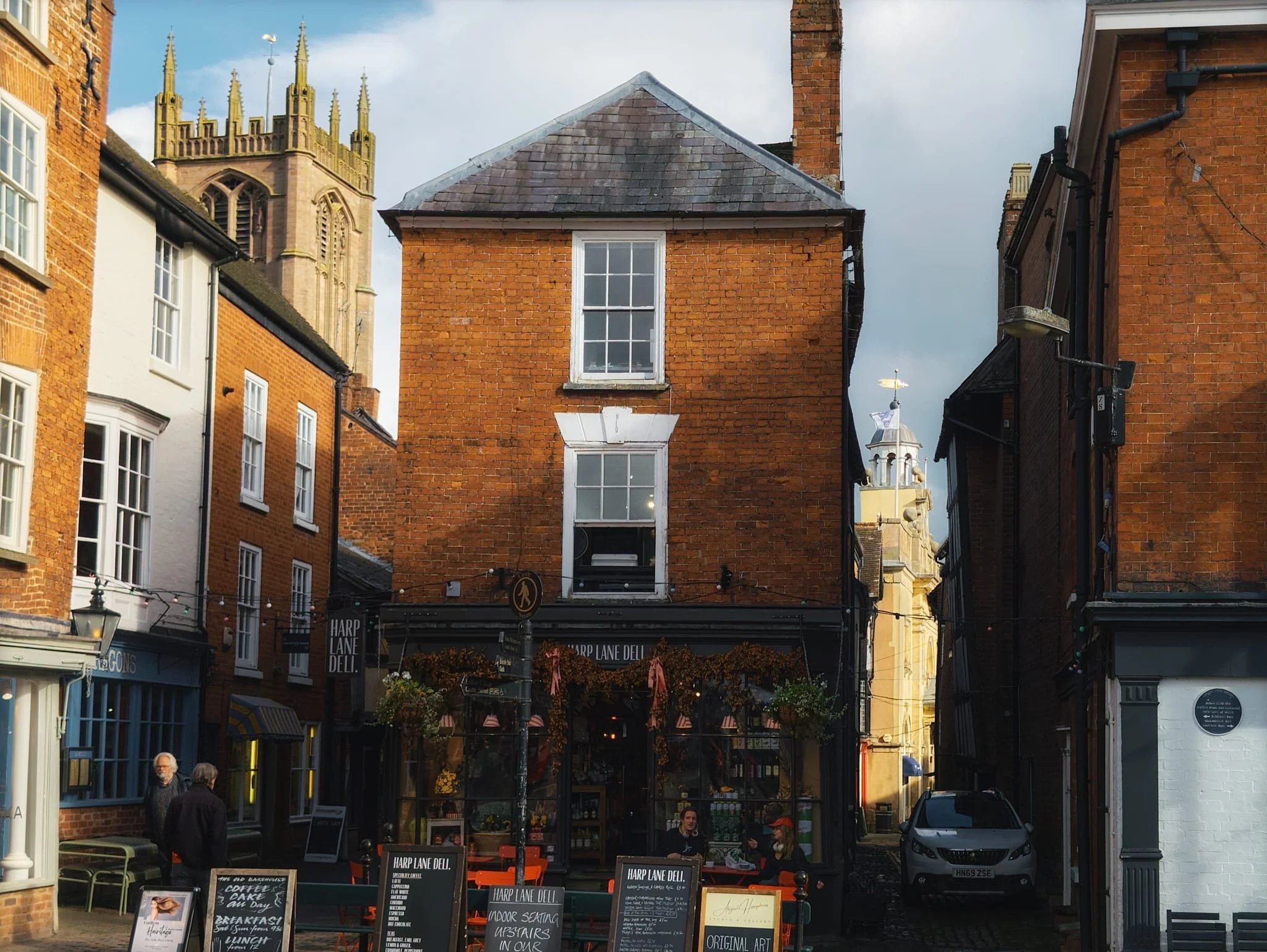 From the Market Square near Ludlow Castle, a view looking back to Ludlow’s wonky buldings, with St. Laurence’s Church and the Butter Cross both draped in golden autumnal light.