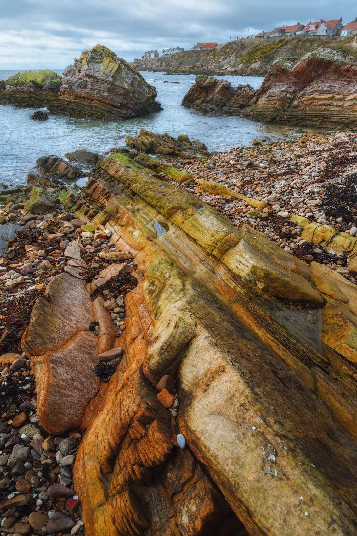 Below Pitenweem, further along the coast, more Sandstone layering is exposed. The beautiful red/brown colours, due to millions of years of oxygen exposure, are complemented with vivid algae greens.
