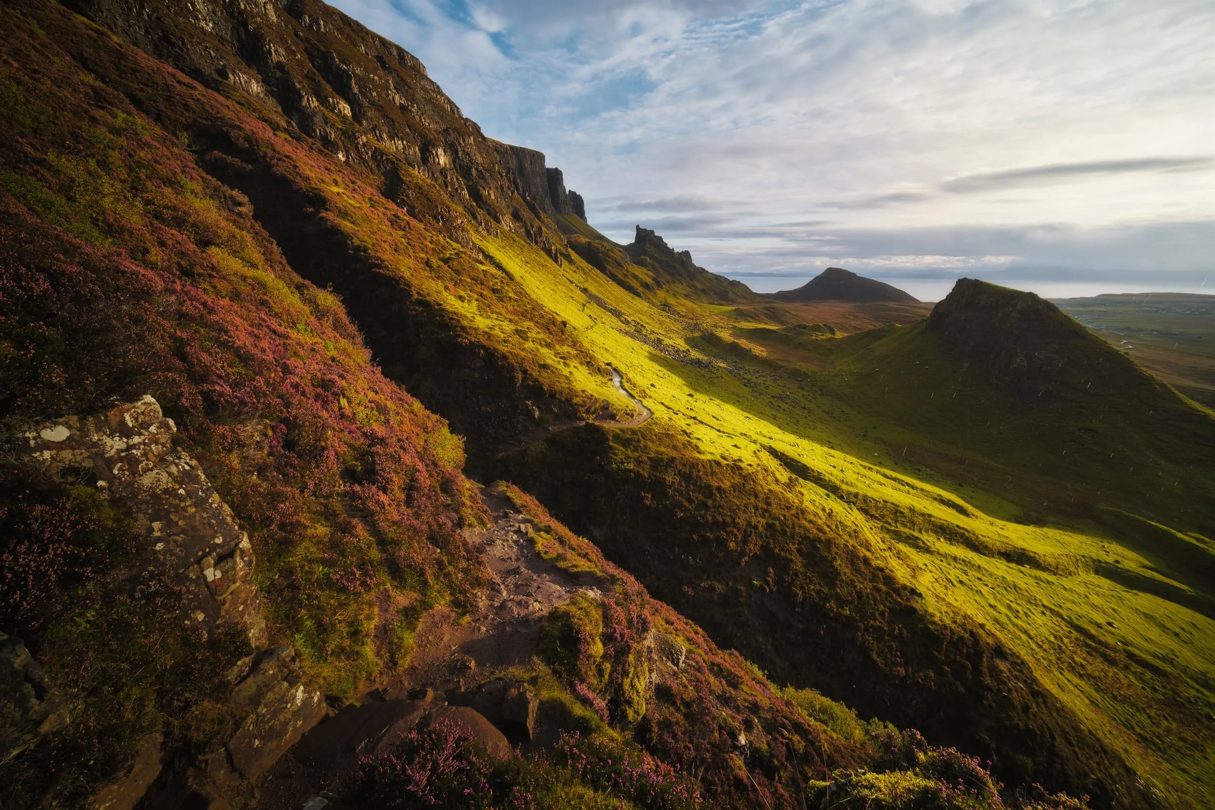 The sun had finally escaped above the bank of cloud that clung to the sea, drenching the Quiraing in intense golden light.