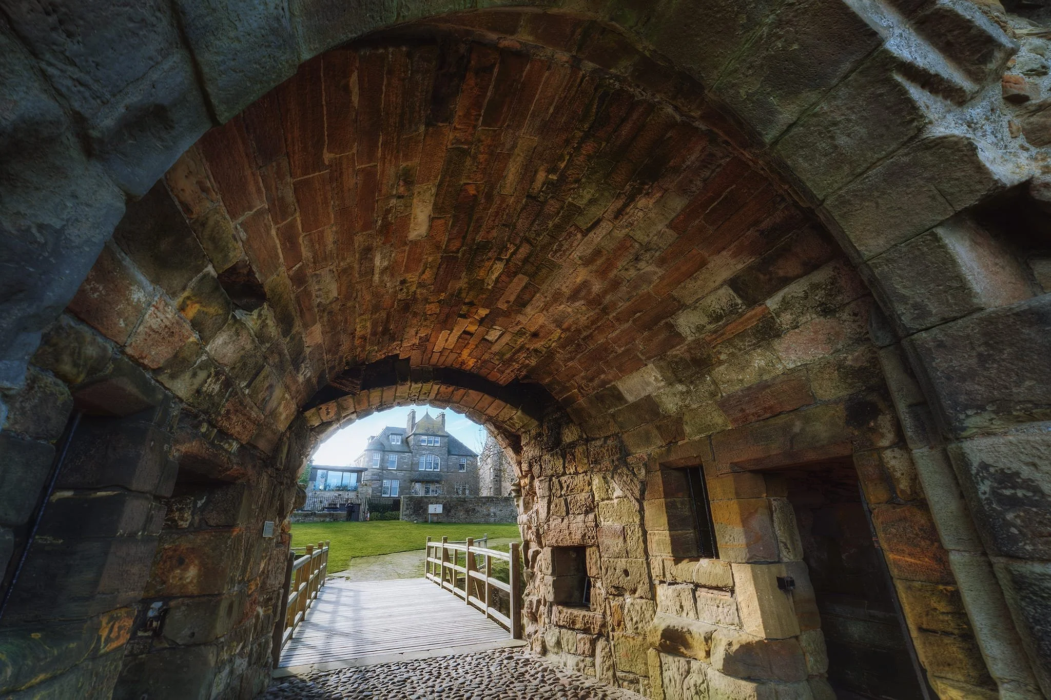 Looking through the entrance to the castle back towards the town. Towards its latter years, the castle was the home of Cardinal David Beaton, Archbishop of St Andrews, the last Scottish cardinal before the Reformation. Cardinal Beaton was not popular, and had no issue using the wealth of the church as his own. Additionally, courtesy of several mistresses, he fathered around 20 illegitimate children, many of whom he later gave well paid positions in the Church. He came to personify everything corrupt and in need of change in the Catholic Church. Eventually he was stabbed to death, mutilated, and hung from a castle window, before being dumped in the castle’s “bottle dungeon” and covered in salt to ‘keip him frome stinking’.