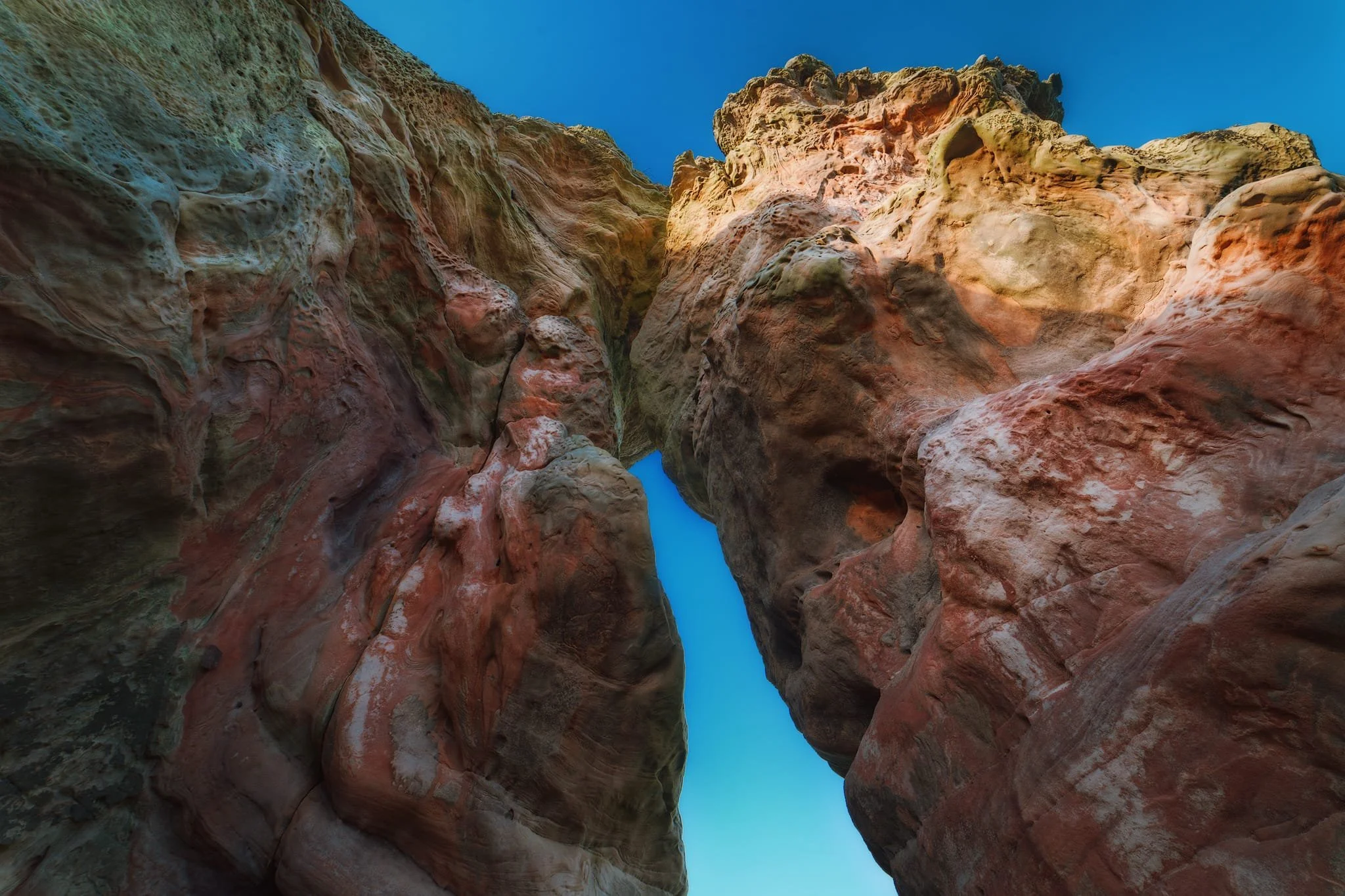 Looking up from underneath the massive arch of Buddo Rock, the setting sun hitting the top of the stack.