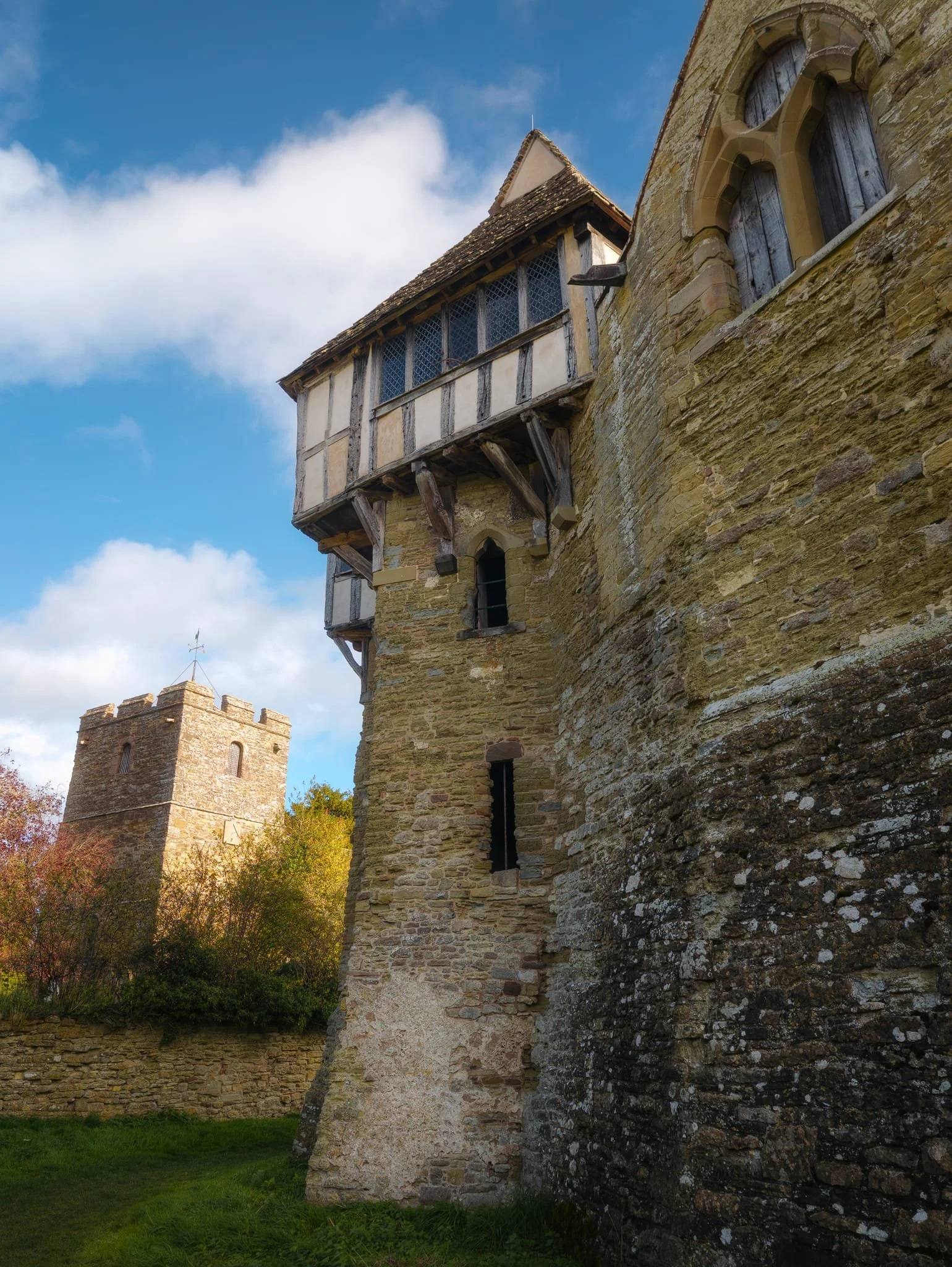 The northern tower of the castle, with the small Church of Saint John the Baptist drenched in autumnal light.