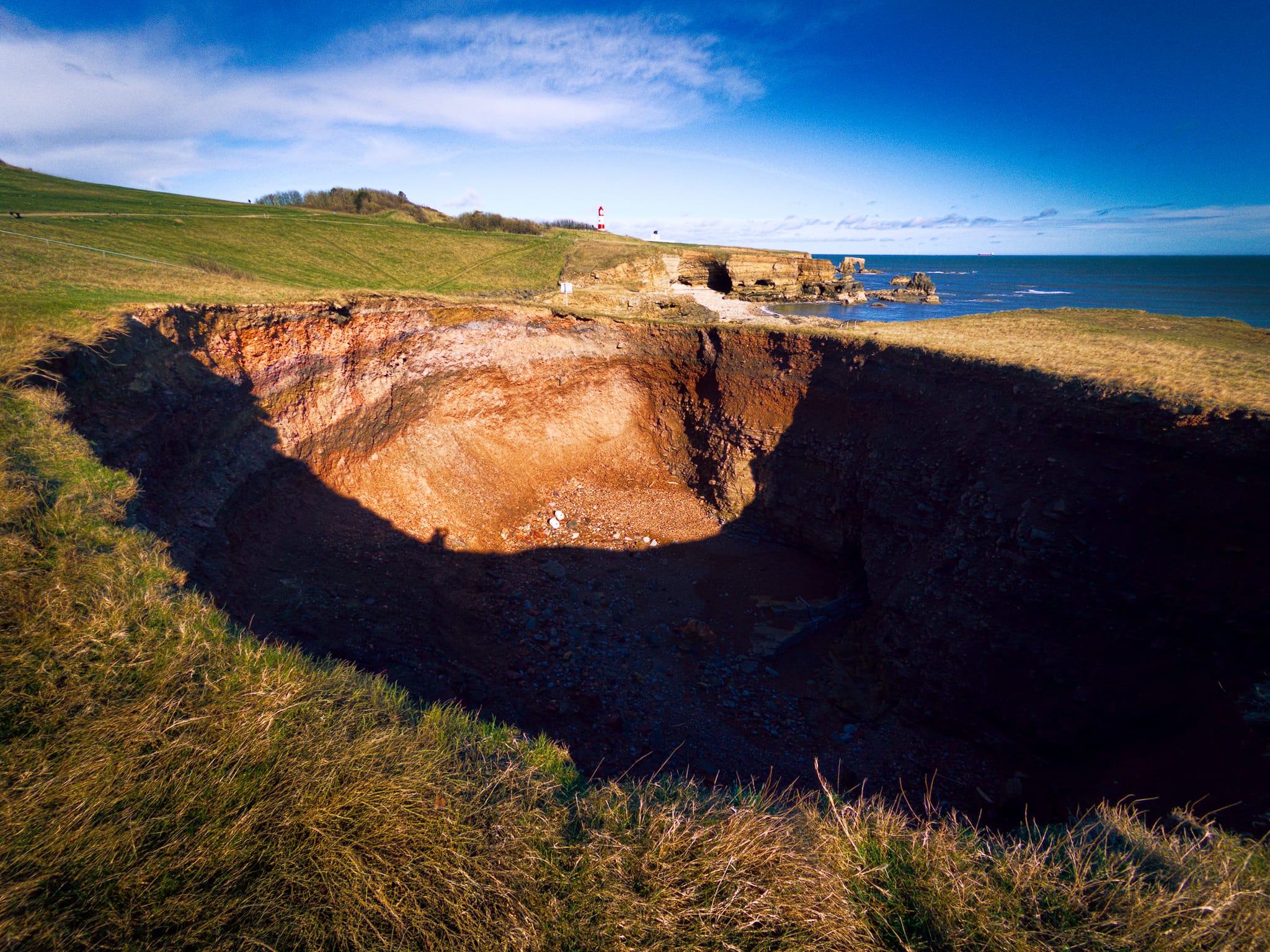 Further north I tentatively edged closer to this massive hole, apparently called Potter’s Hole. It’s a little away from the cliffs, but in time I’m sure this hole will join the sea and form a bay.